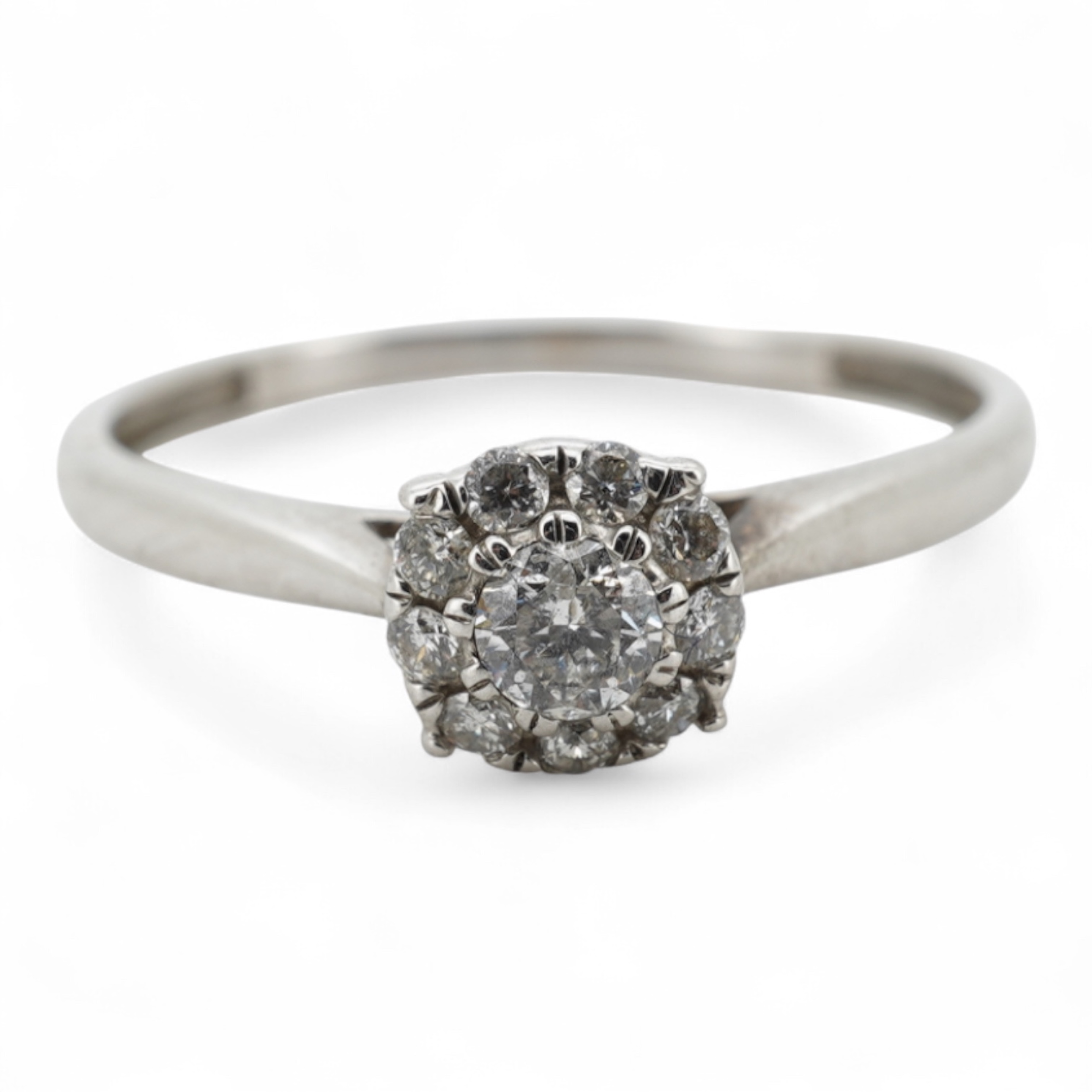 A diamond cluster ring, claw-set with a brilliant-cut diamond weighing approximately 0.10 carats, within a border of smaller brilliant-cut diamonds totalling approximately 0.09 carats, mounted in unmarked white metal, si